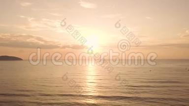 在夏季海滩的海水上空鸟瞰五彩缤纷的日出。 金色天空和阳光下美丽的日落